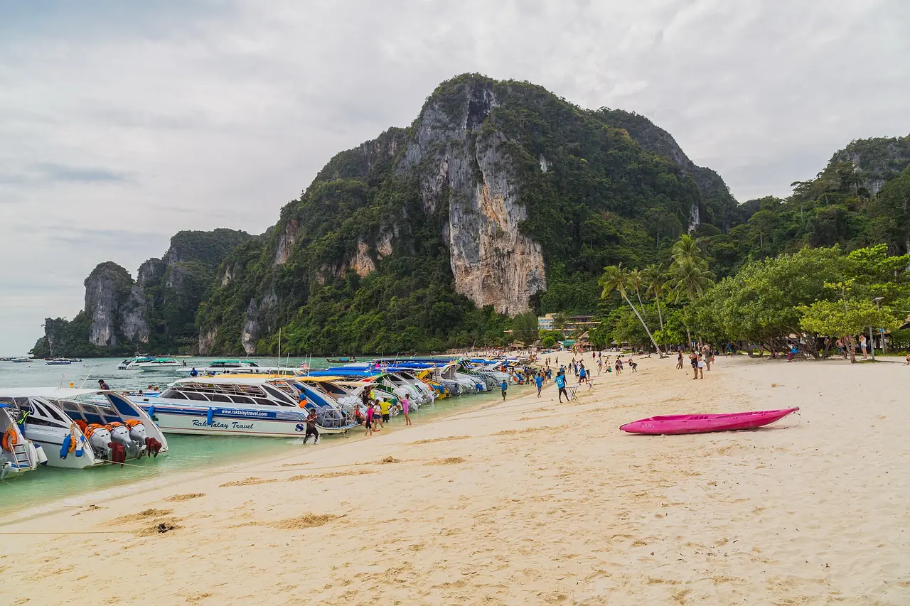 Ton Sai Beach on Phi Phi Don with moored speedboats and a limestone cliff behind