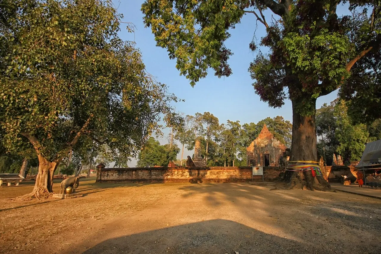 Large trees and a small chedi at Wat Pho Prathap Chang; the Commons file names the temple