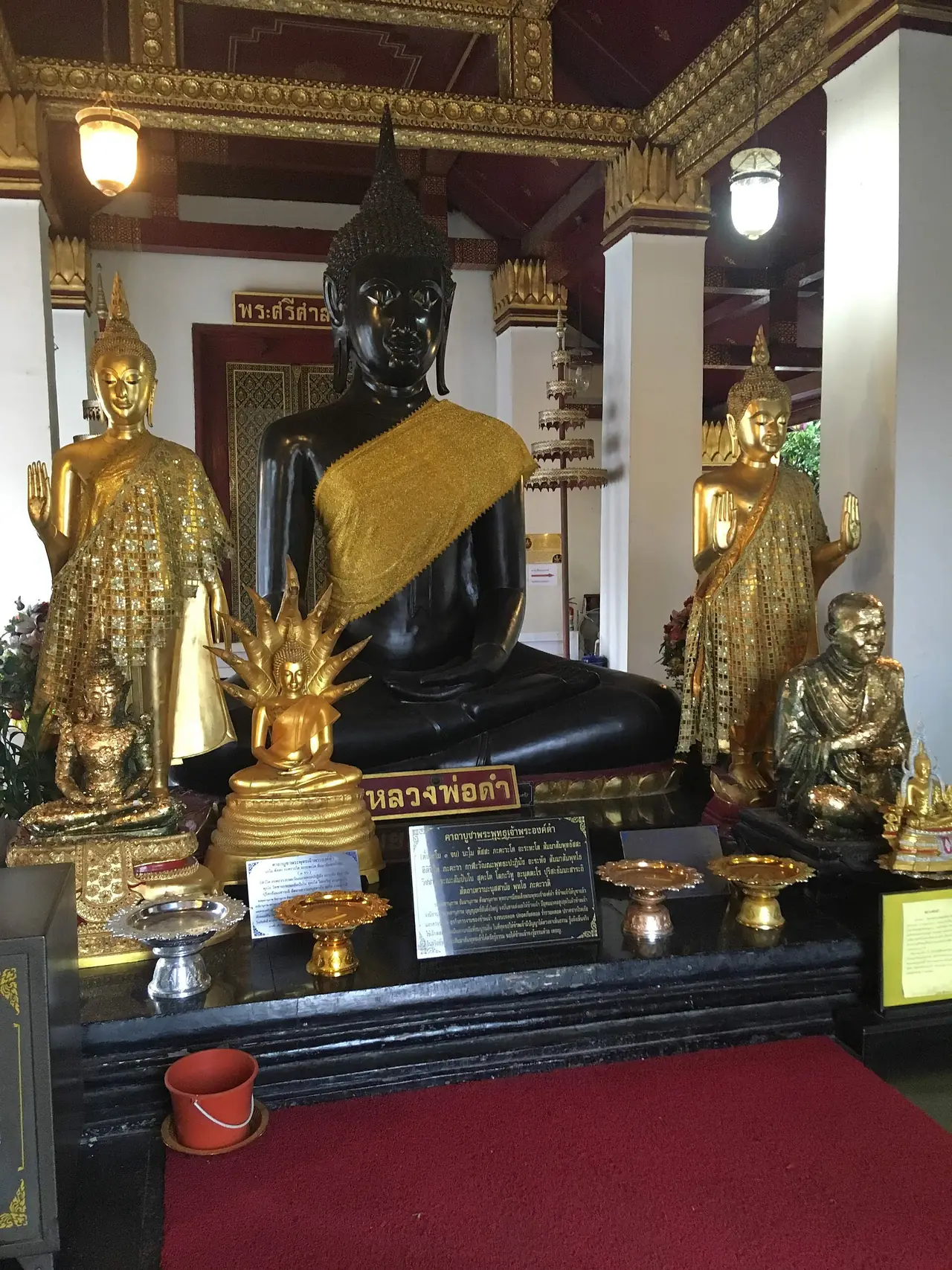 พระพุทธรูปสีดำพร้อมพระสาวกยืนสองข้างในบริเวณวัดใหญ่ ภาพของ Christophe95 จาก Wikimedia Commons ไม่ได้ระบุชื่อองค์พระ
