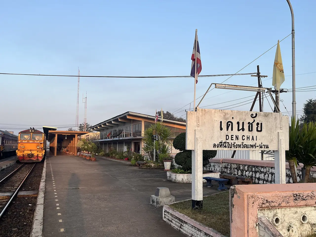 สถานีรถไฟเด่นชัย ป้ายสถานีและหัวรถจักรสีส้มที่ชานชาลา ภาพของ Tealsp จาก Wikimedia Commons CC0 สถานีที่ต้องลงถ้าเดินทางด้วยรถไฟไปแพร่