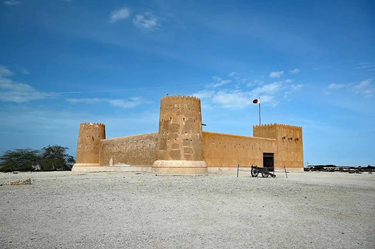 ป้อม Al Zubarah ที่สร้างปี 2481 ตัวอาคารสีทรายมีหอสี่มุม ภาพจาก Wikimedia Commons ผู้ถ่าย P. Hughes สัญญา CC BY 4.0