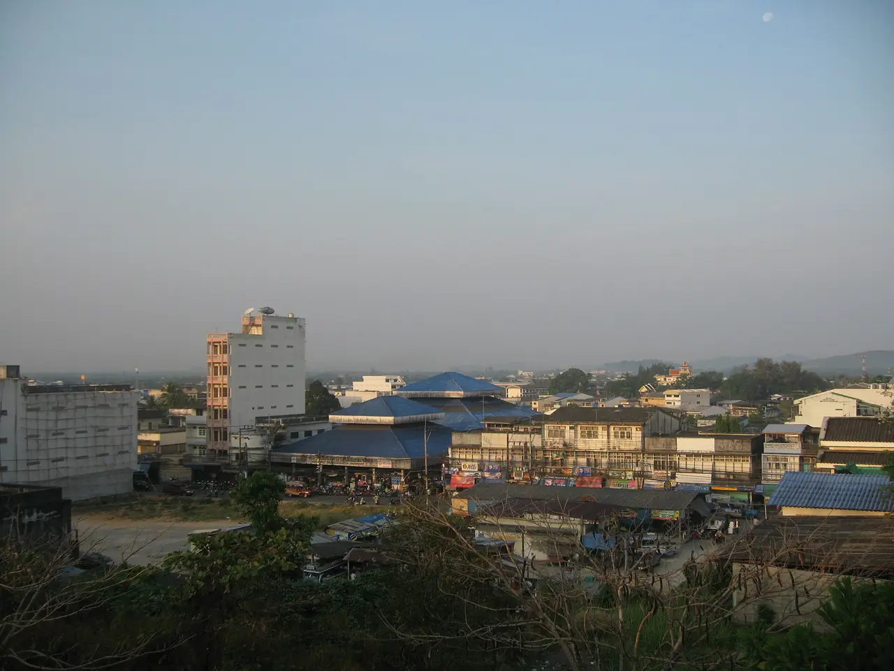 ทิวหลังคาตัวเมืองระนองมีเนินเขาอยู่ด้านหลัง มองจากที่สูง