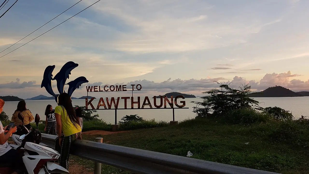 ป้ายต้อนรับสู่เมืองคอตอง (Kawthaung) ริมทะเลมีเกาะอยู่ไกล ๆ ภาพของ Kyaw_Zin_Win(KT) จาก Wikimedia Commons ใบอนุญาต CC BY 4.0