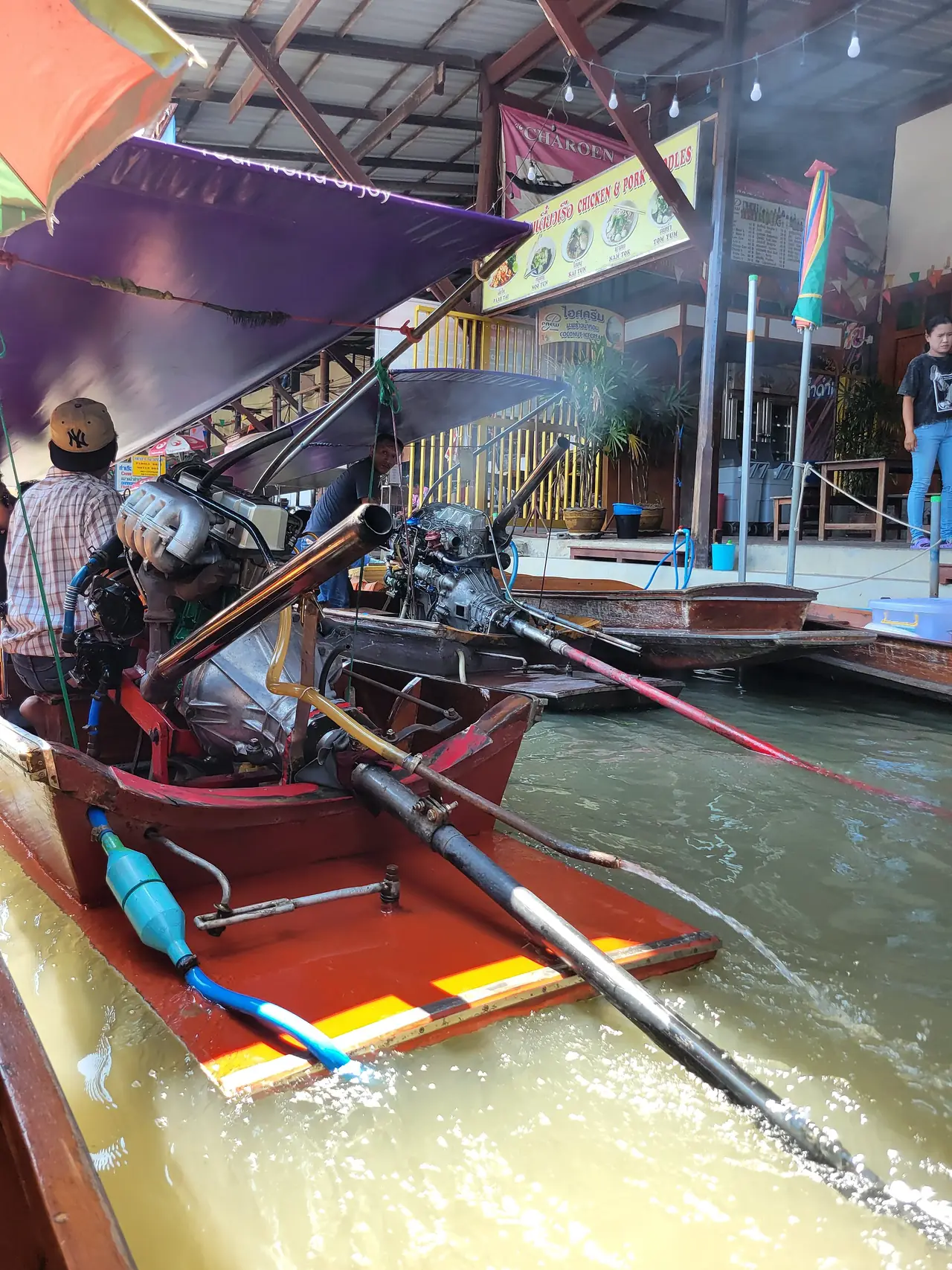 เรือหางยาวในคลองบริเวณตลาดน้ำดำเนินสะดวก ภาพของ Welcome to Thailand จาก Wikimedia Commons ใบอนุญาต CC0