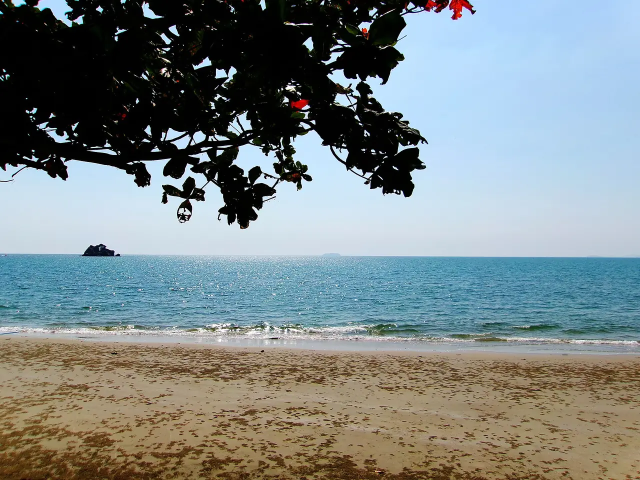 The calm sea at Laem Mae Phim beach under a shade tree