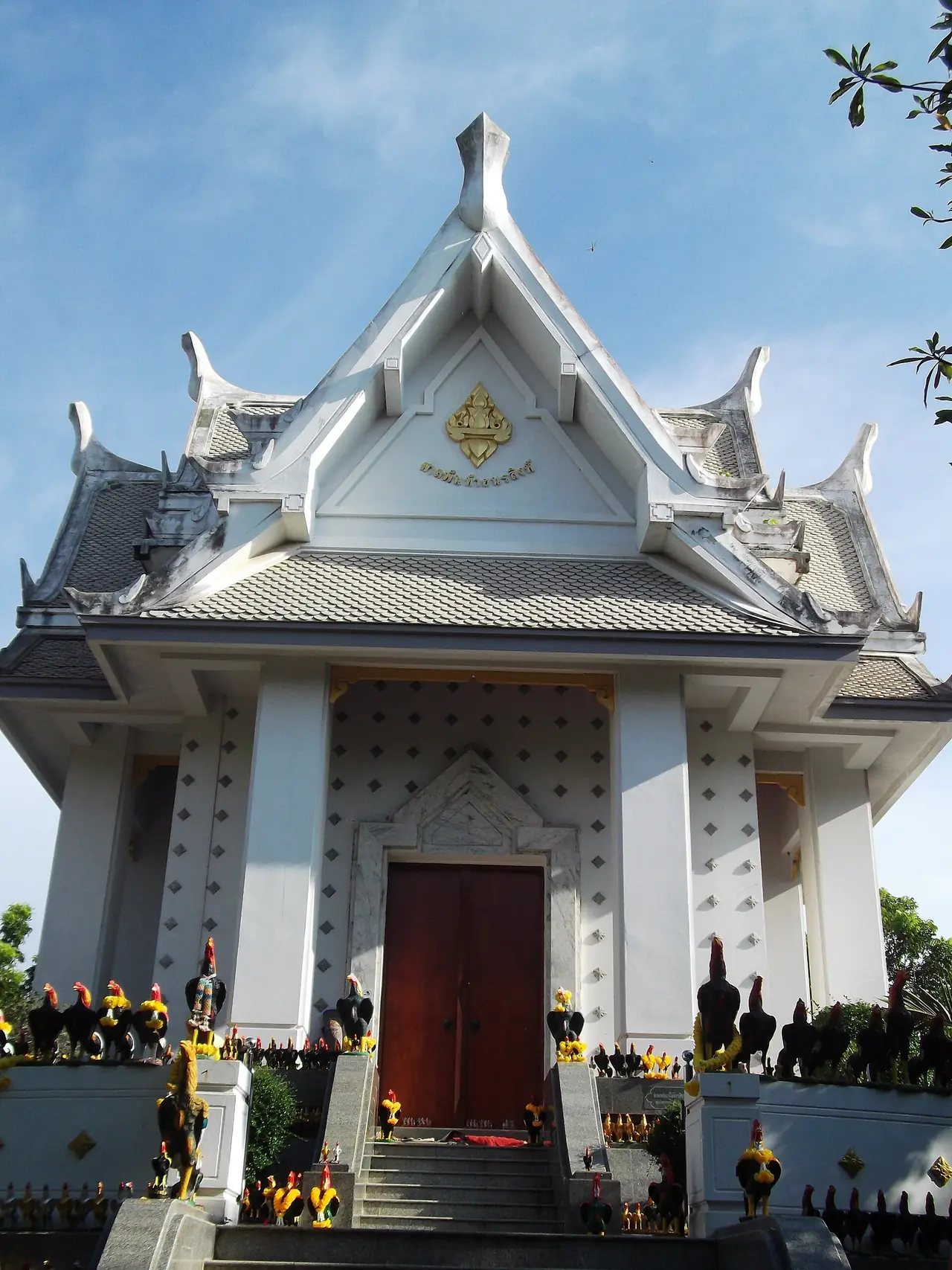 ศาลพันท้ายนรสิงห์ มีรูปปั้นไก่ถวายเรียงอยู่หน้าศาล ภาพจาก Wikimedia Commons