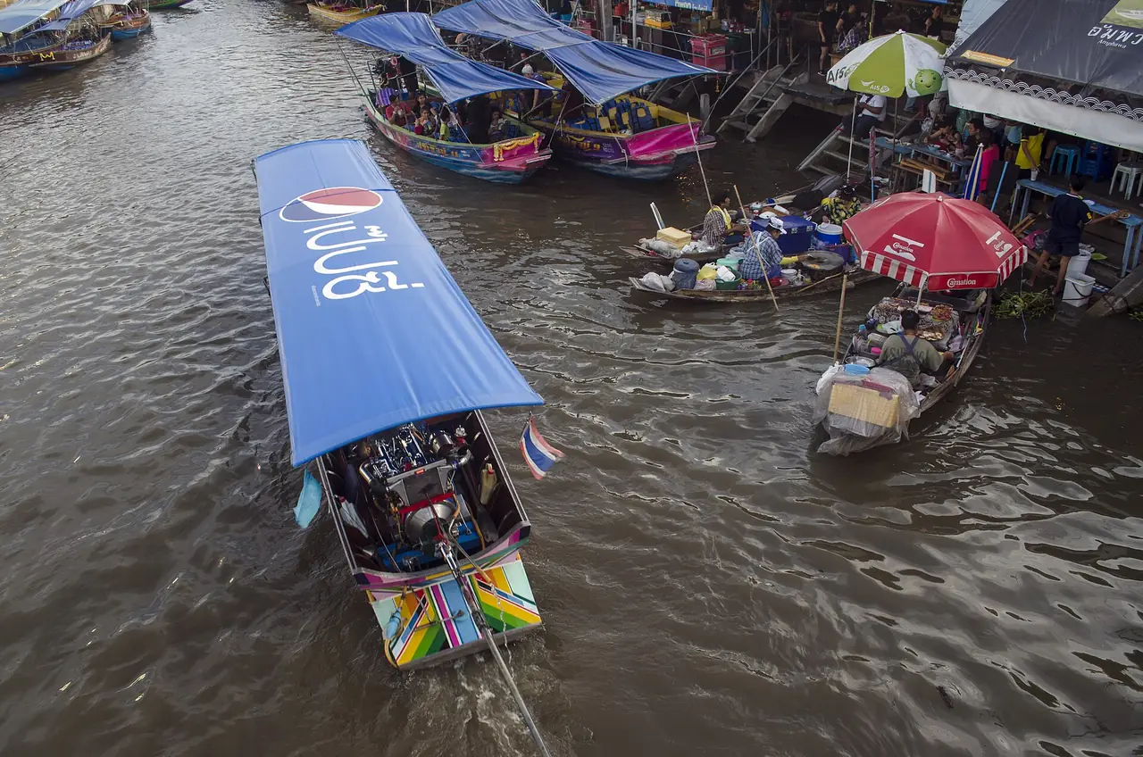 A passenger boat and vendor boats on the Amphawa canal, seen from above
