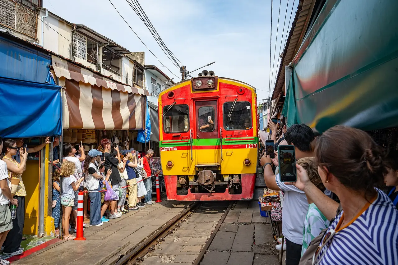 รถไฟผ่านตลาดร่มหุบ ภาพของ Takeshi Aida จาก Wikimedia Commons ใบอนุญาต CC BY-SA 2.0