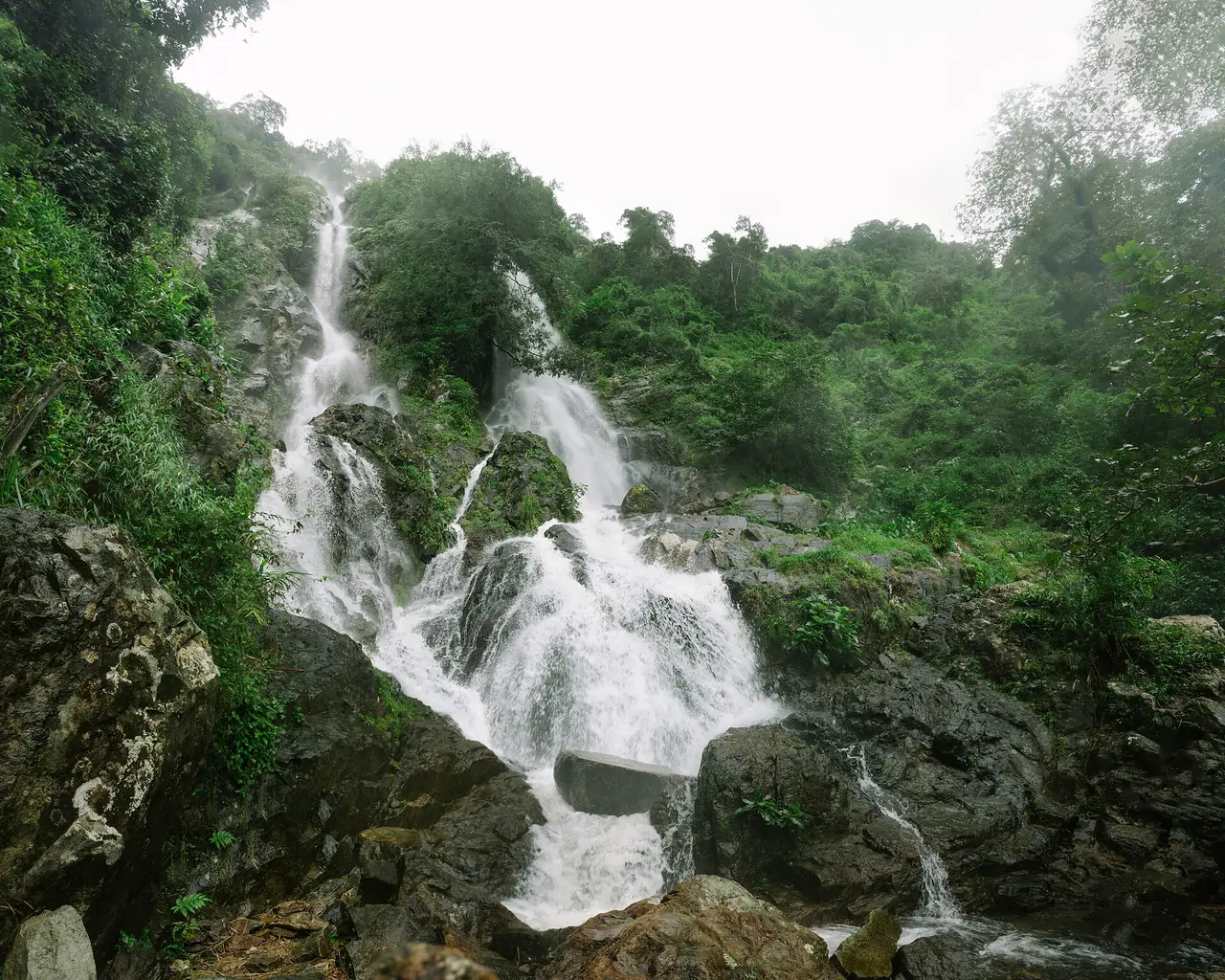 น้ำตกโกรกอีดกไหลลงหลายชั้นท่ามกลางป่า ภาพของ Kasinsonla จาก Wikimedia Commons ใบอนุญาต CC BY-SA 4.0