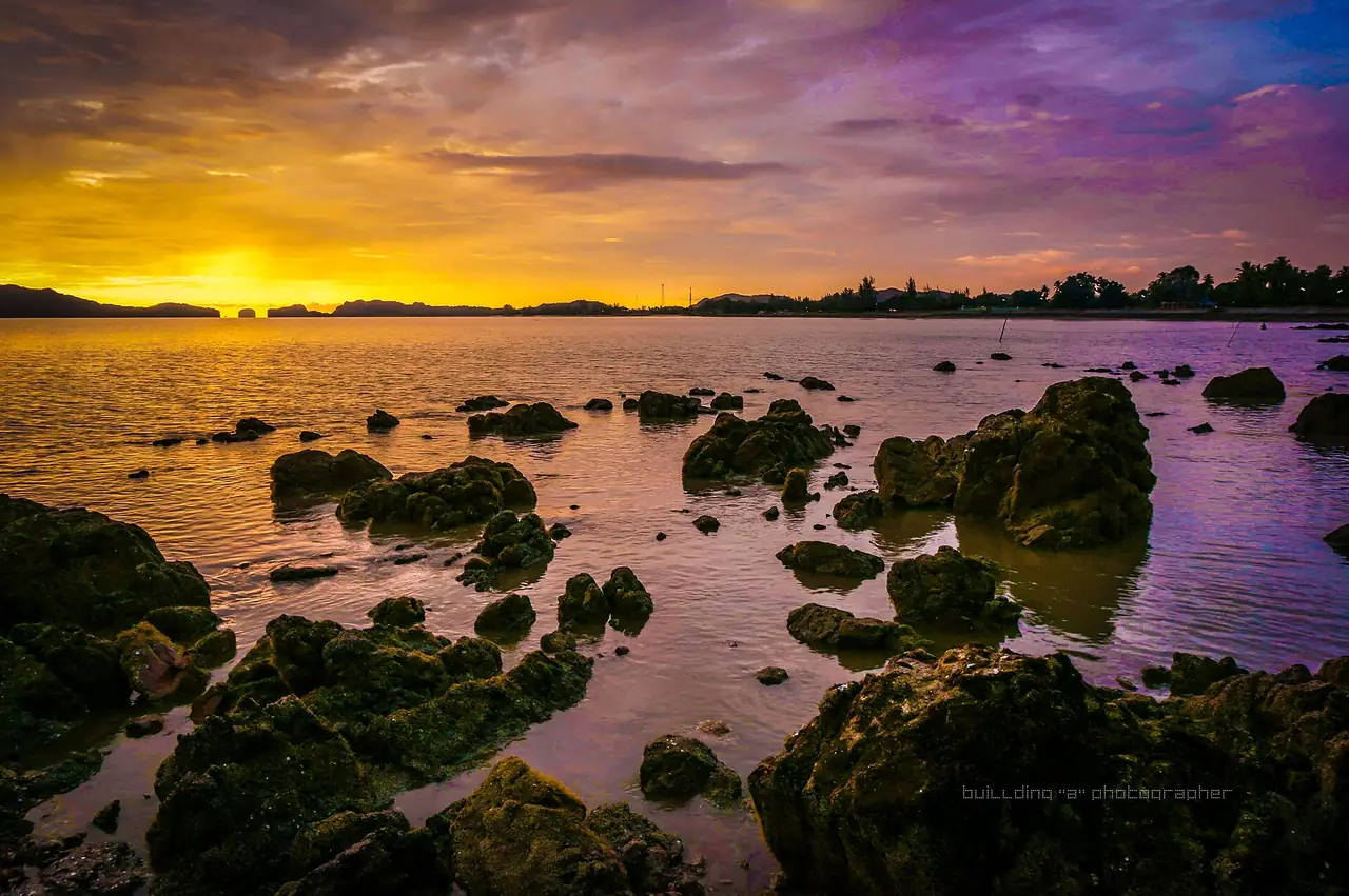 Rocky shore and a purple sunset over the sea at Pak Nam, La-ngu, Satun