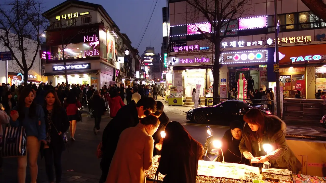 ถนนย่านฮงแดยามค่ำ มีร้านค้าและแผงอาหารตามทาง