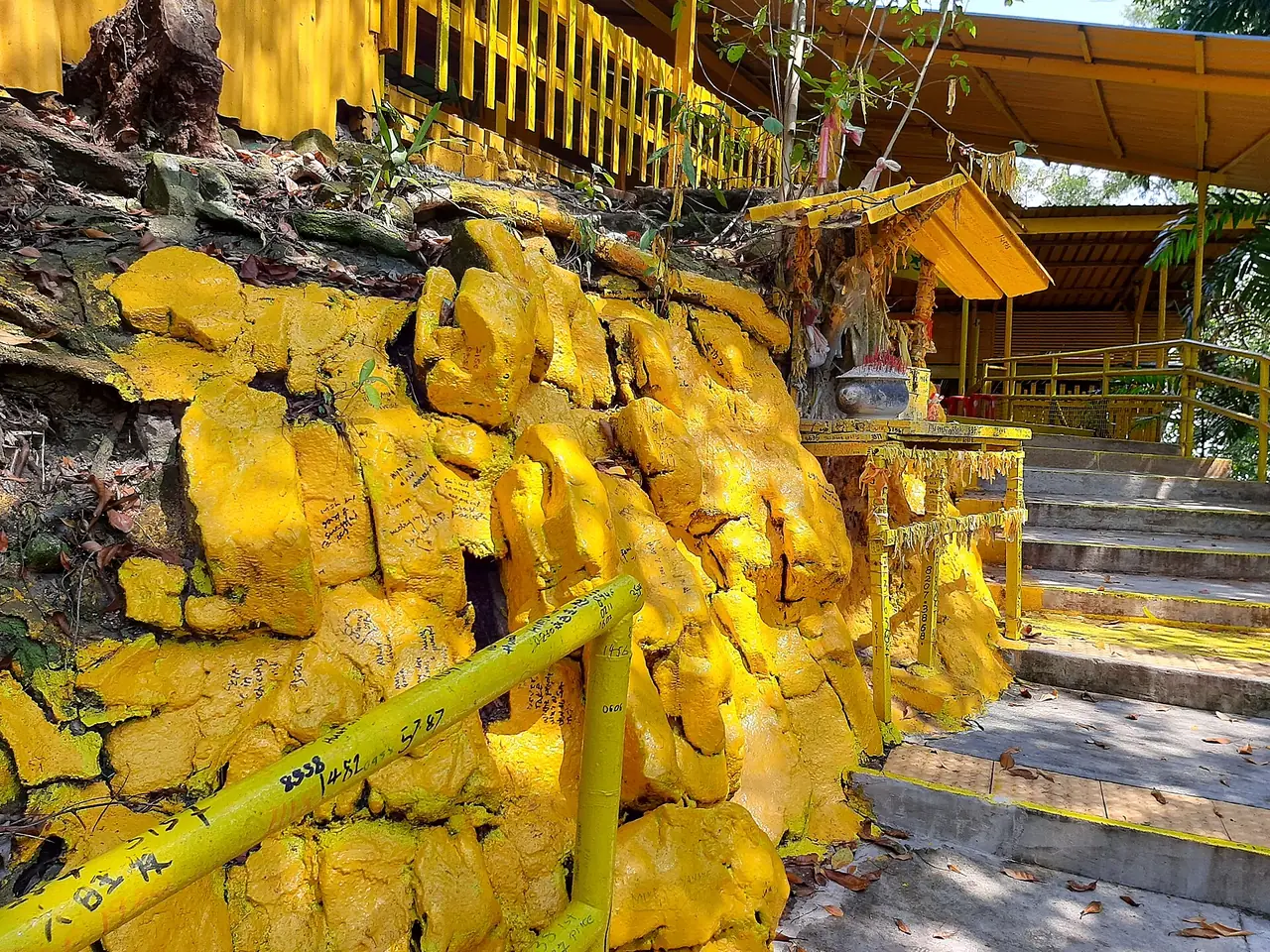 ก้อนหินทาสีเหลืองและทางเข้าศาลที่ Keramat Kusu ภาพจาก Wikimedia Commons ผู้ถ่าย Kbseah สัญญา CC BY-SA 4.0