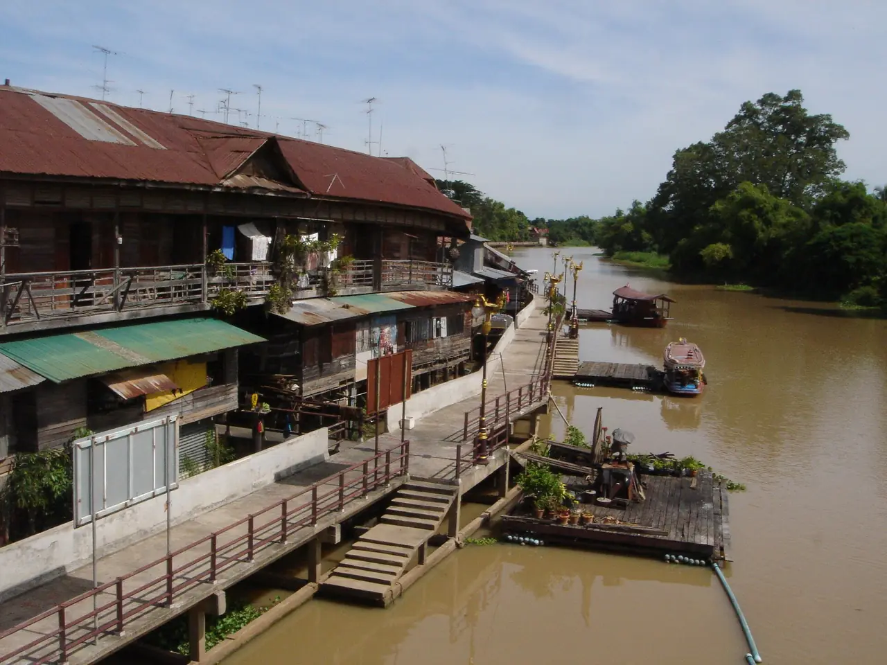 The Tha Chin River bank at Sam Chuk 100-year market, with wooden houses and a boardwalk