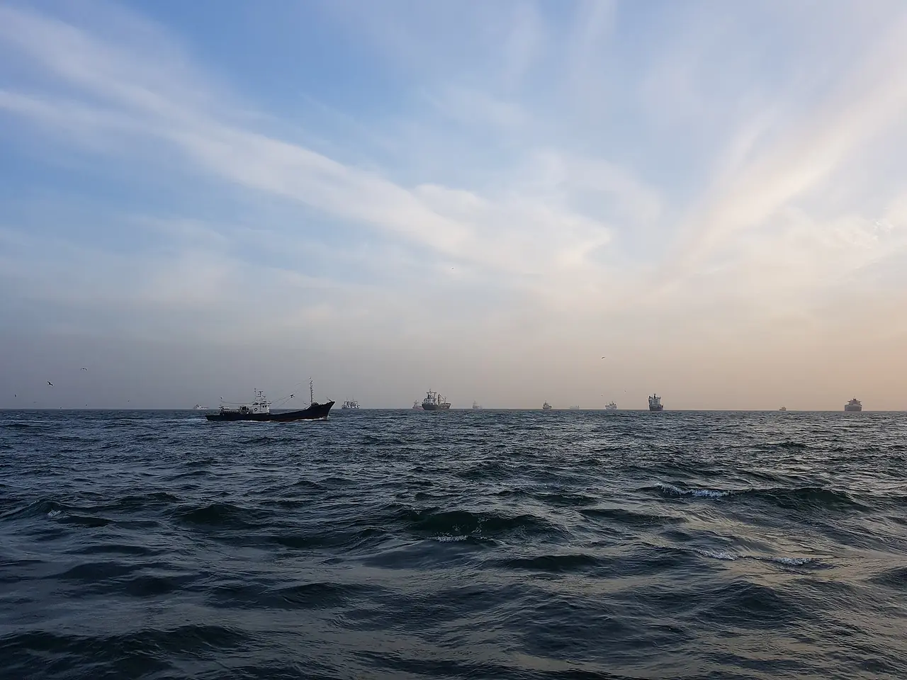 ท้องทะเลยามเย็นนอกชายฝั่งแทจงแด มีเรือสินค้าลอยอยู่ไกล ๆ