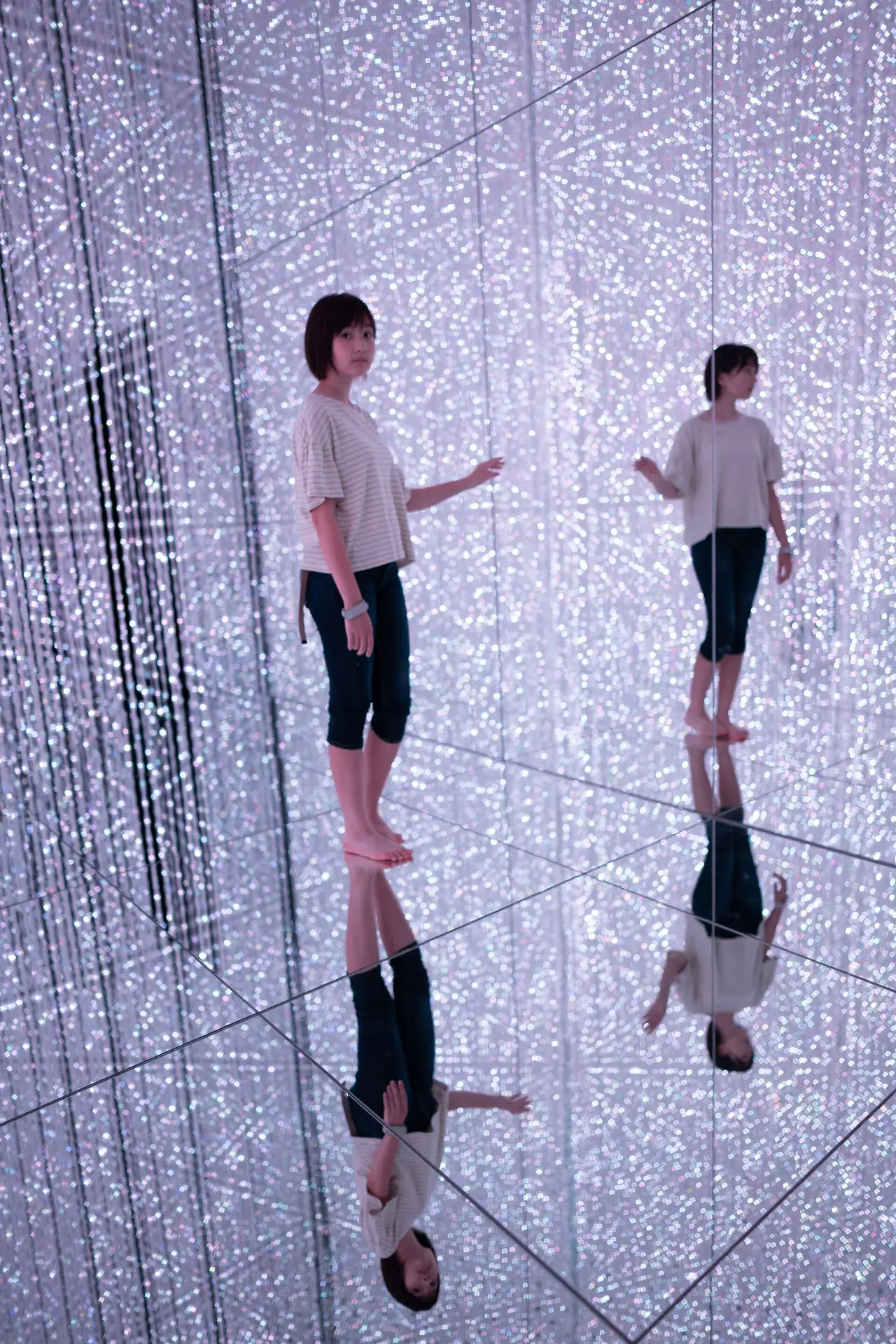 ห้องกระจกเงาที่ teamLab Planets ผู้เข้าชมสะท้อนบนพื้นและผนัง