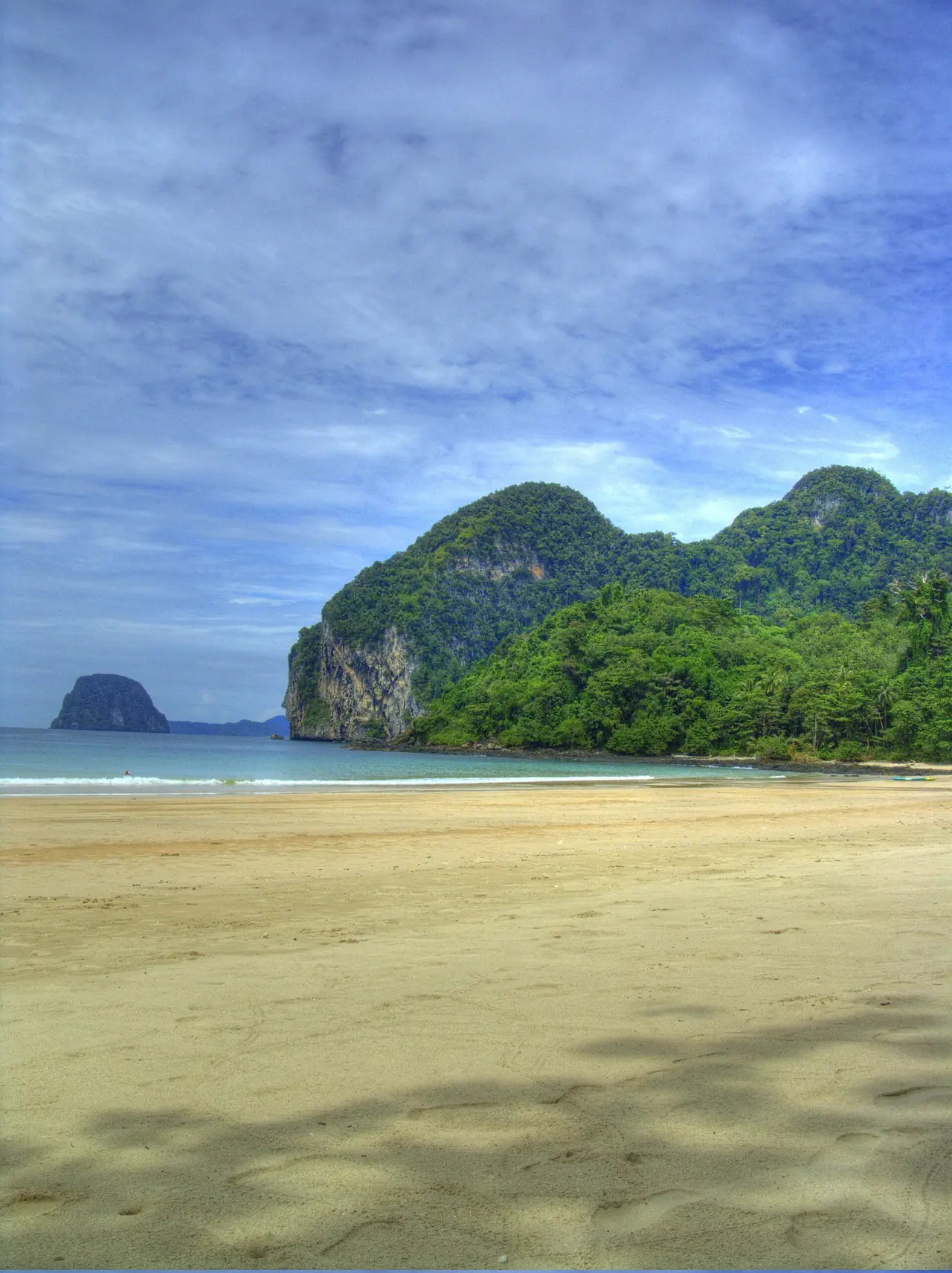 หาดทรายและภูเขาป่าเขียวบนเกาะมุก ภาพจากชายหาด Charlie Beach ภาพถ่ายจาก Wikimedia Commons
