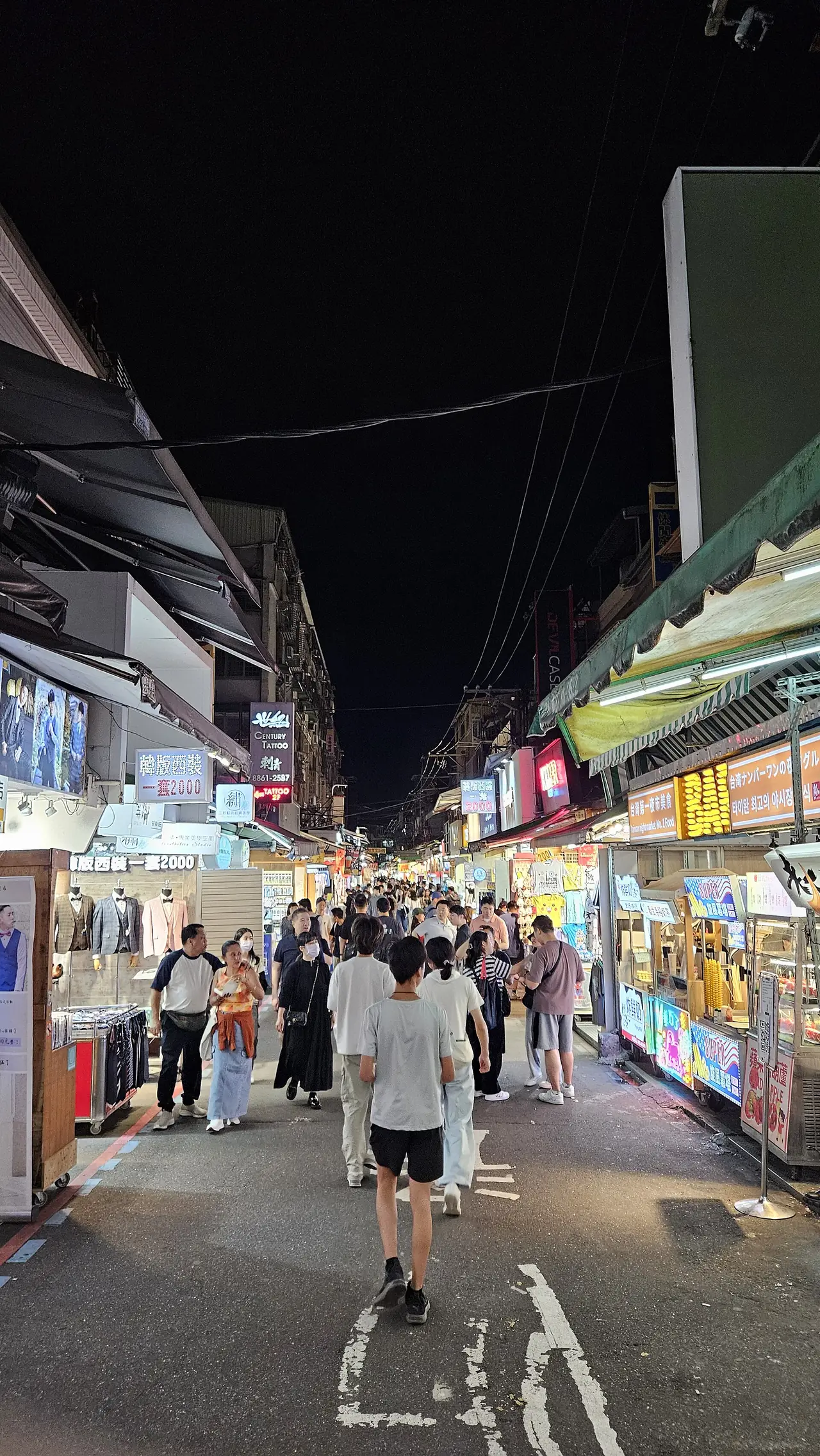 แผงอาหารเรียงตามถนน Dadong ในย่านตลาดกลางคืนซื่อหลิน คนเดินแน่นช่วงค่ำ ภาพจาก Wikimedia Commons ผู้ถ่าย Ganmatthew สัญญา CC BY 4.0