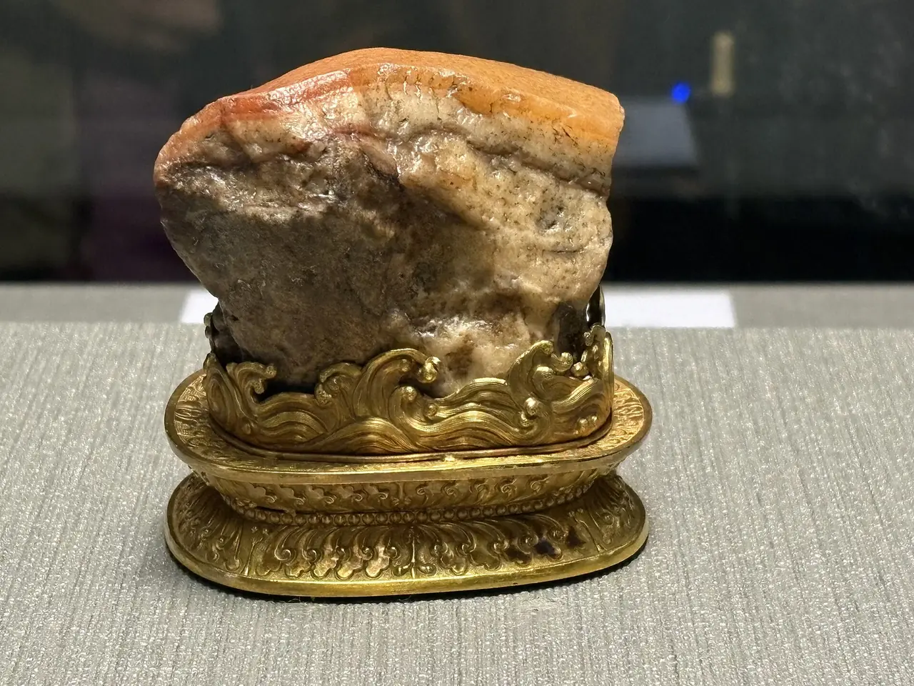 หินรูปหมูสามชั้น (Meat-shaped Stone) บนฐานทองในตู้จัดแสดง ภาพปี 2568 จาก Wikimedia Commons ผู้ถ่าย Chainwit. สัญญา CC BY 4.0
