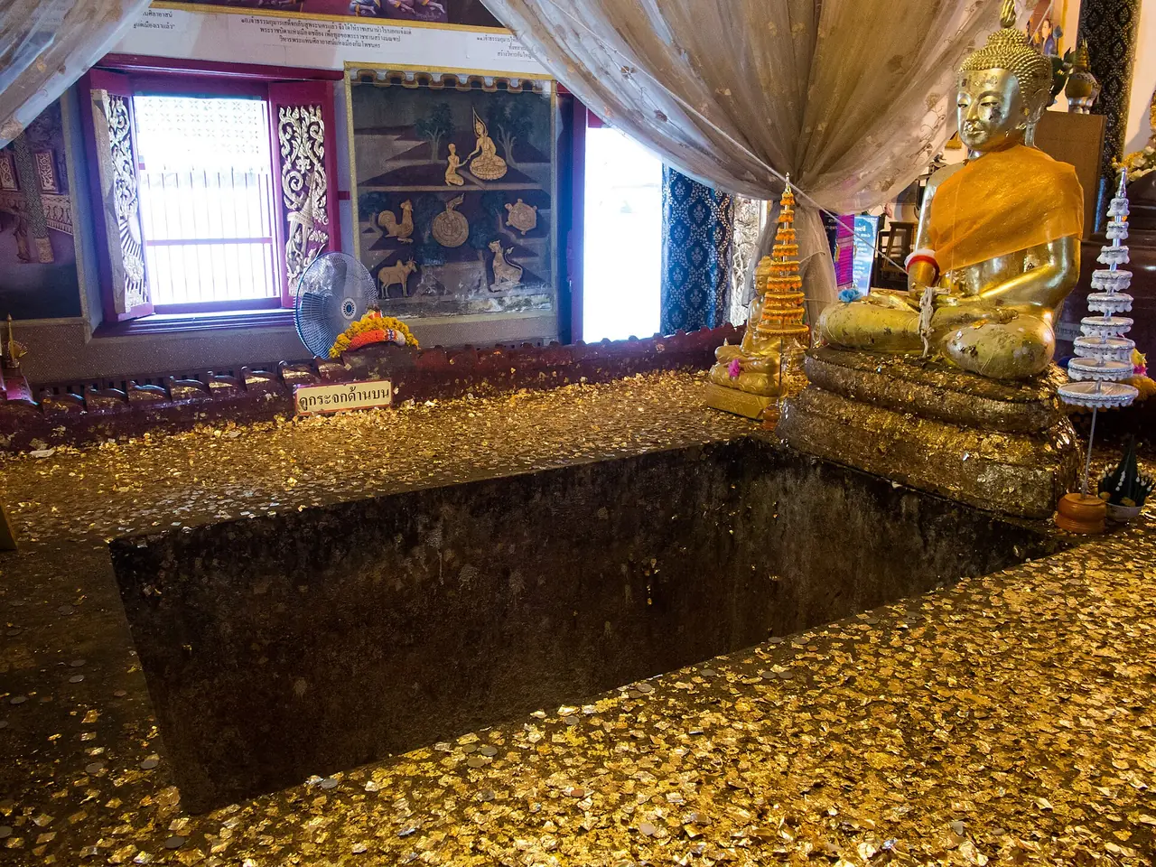 หลุมบนฐานศิลาแลงที่วัดพระแท่นศิลาอาสน์ ภาพของ Takeaway จาก Wikimedia Commons ใบอนุญาต CC BY-SA 3.0 คำบรรยายบน Commons ว่าฐานนี้เชื่อกันว่าสร้างสมัยสุโขทัย