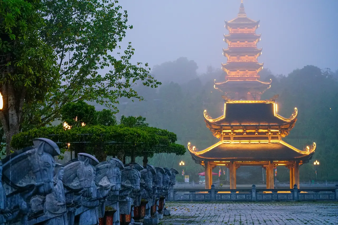 หอเจดีย์และอาคารในวัดบ๋ายดิ๋ญช่วงเย็นที่เปิดไฟ ภาพจาก Wikimedia Commons ผู้ถ่าย Travelphotographery สัญญา CC BY-SA 4.0 ถ่าย ก.พ. 2566