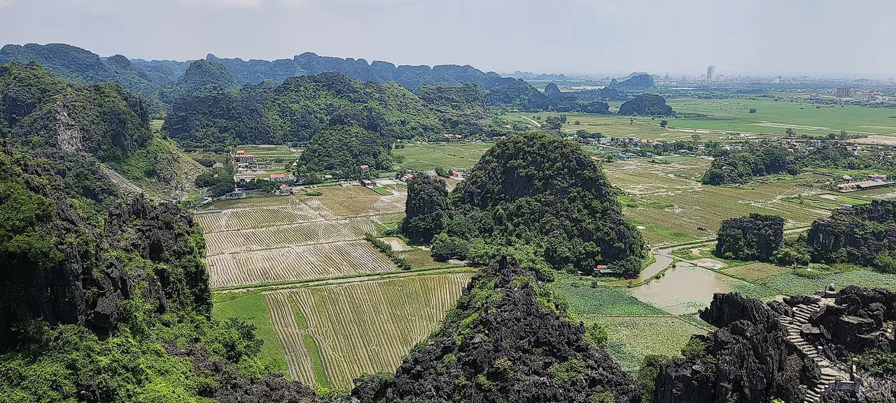 วิวจากจุดชมวิวถ้ำมัวมองลงไปเห็นนาข้าวและเขาหินปูนของทามก๊ก ภาพจาก Wikimedia Commons ผู้ถ่าย Shyamal สัญญา CC BY-SA 4.0