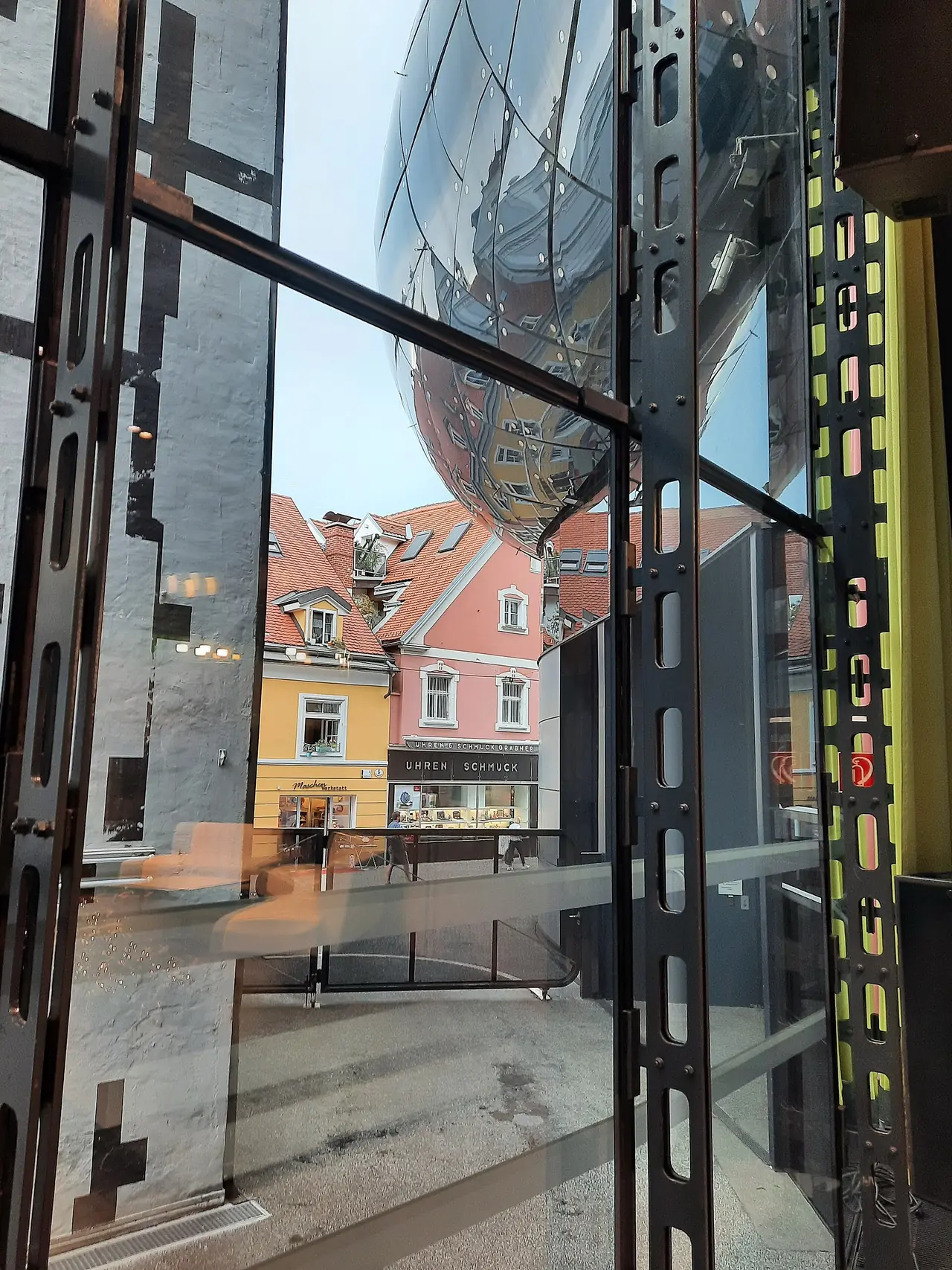 ภายใน Kunsthaus Graz มองผ่านกระจกออกไปเห็นอาคารเมืองเก่า ภาพจาก Wikimedia Commons ผู้ถ่าย Peter Christian Riemann สัญญา CC BY-SA 4.0