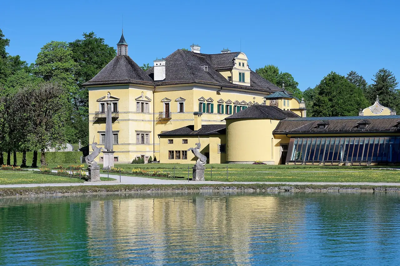 ปราสาท Hellbrunn มองจากทางตะวันออกเฉียงใต้ เห็นสระน้ำหน้าปราสาท ภาพจาก Wikimedia Commons ผู้ถ่าย Jakub Hałun สัญญา CC BY 4.0 (ถ่ายพฤษภาคม 2569)