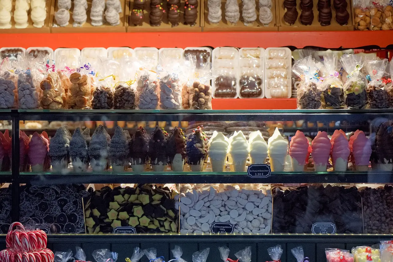 ขนมและลูกกวาดหลากสีที่แผงในตลาดคริสต์มาสบนลาน Domplatz ภาพจาก Wikimedia Commons ผู้ถ่าย Eweht สัญญา CC BY-SA 4.0 (ถ่ายธันวาคม 2566 เป็นภาพของปีก่อน)