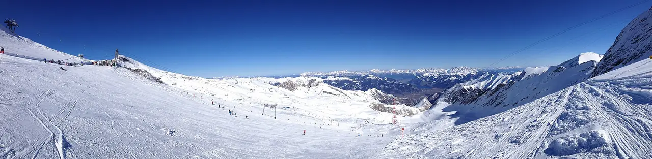 พื้นที่สกีบนธารน้ำแข็ง Kitzsteinhorn มองไปทาง Kaprun และ Zell am See ภาพจาก Wikimedia Commons ผู้ถ่าย Matlcommons สัญญา CC BY-SA 3.0 (ภาพฤดูหนาว)