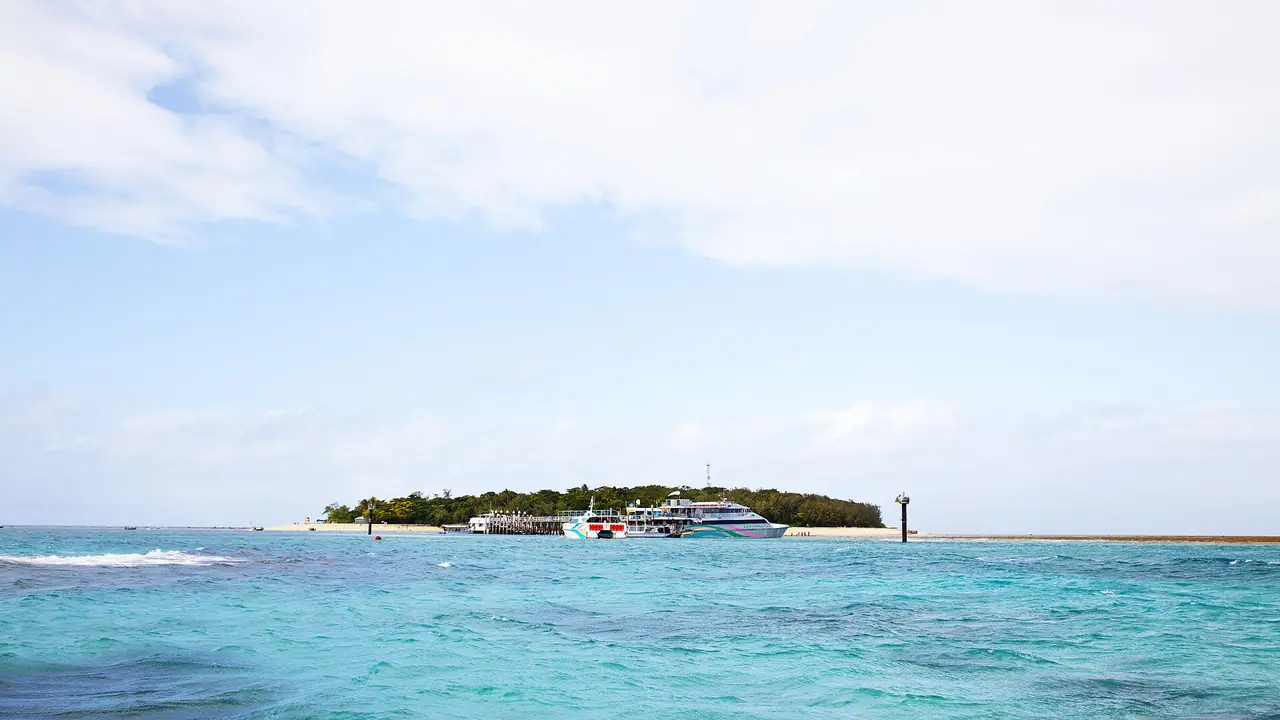 เกาะ Green Island มองจากท่าเทียบเรือ มีเรือทัวร์จอดอยู่ในแนวน้ำตื้น ภาพจาก Wikimedia Commons ผู้ถ่าย Michał Rosa สัญญา CC BY-SA 3.0 ไม่ระบุปี