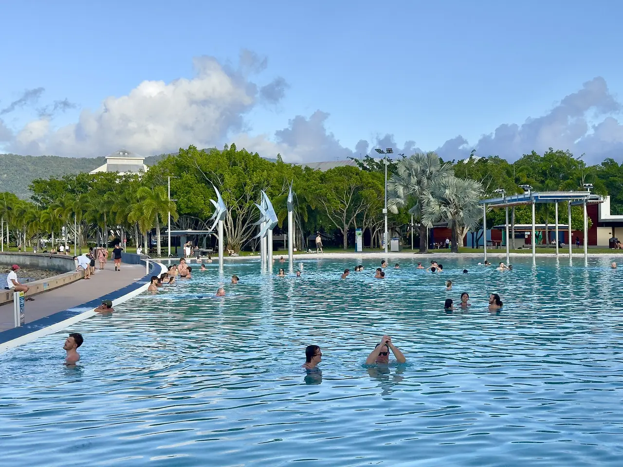คนว่ายน้ำใน Esplanade Lagoon ริมทะเลที่แคนส์ ภาพจาก Wikimedia Commons ผู้ถ่าย Chris Olszewski สัญญา CC BY-SA 4.0 ถ่ายปี 2025