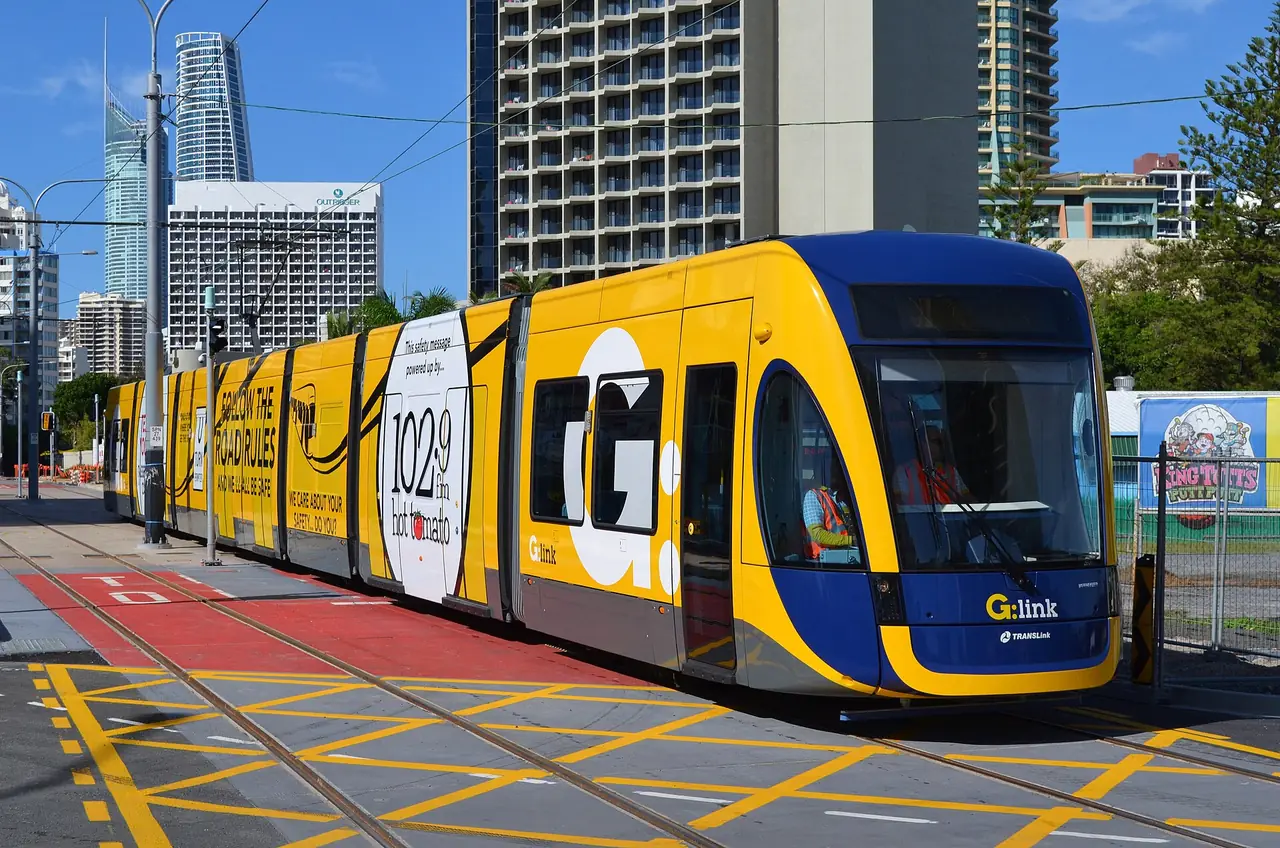 รถราง G:link สีเหลืองน้ำเงินบน Surfers Paradise Boulevard ภาพจาก Wikimedia Commons ผู้ถ่าย Bahnfrend สัญญา CC BY-SA 3.0 ถ่ายปี 2014 ตอนทดสอบระบบ ภาพเก่า