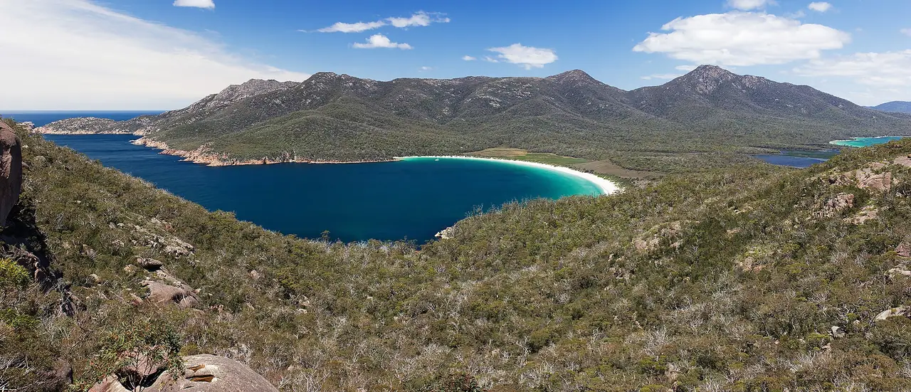 อ่าว Wineglass Bay มองจากจุดชมวิว Freycinet National Park ภาพจาก Wikimedia Commons ผู้ถ่าย JJ Harrison สัญญา CC BY-SA 3.0