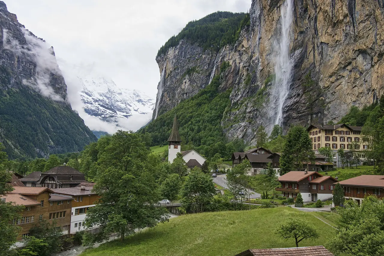 หมู่บ้าน Lauterbrunnen มองเห็นโบสถ์ น้ำตก Staubbach และภูเขาหิมะ ภาพจาก Wikimedia Commons ผู้ถ่าย chensiyuan สัญญา CC BY-SA 4.0 ภาพปี 2555 เป็นภาพประกอบหน้าร้อน