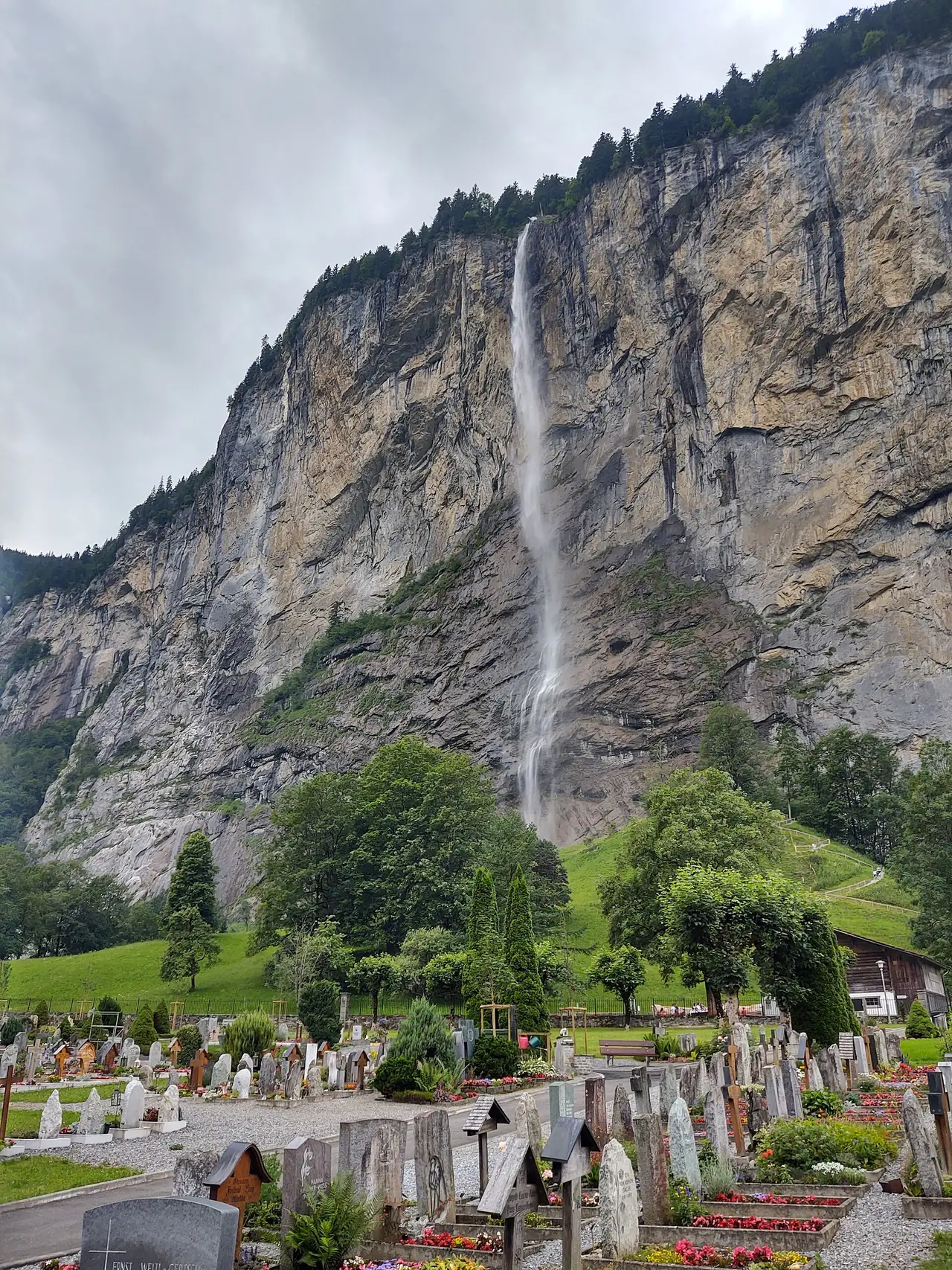 น้ำตก Staubbach ที่ตกจากหน้าผาเหนือสุสานของหมู่บ้าน Lauterbrunnen ภาพจาก Wikimedia Commons ผู้ถ่าย Sabrina Schreiber สัญญา CC BY-SA 4.0 ไม่ทราบวันที่ถ่าย ปริมาณน้ำเปลี่ยนตามฤดู ภาพนี้ถ่ายหน้าร้อนช่วงอากาศครึ้ม