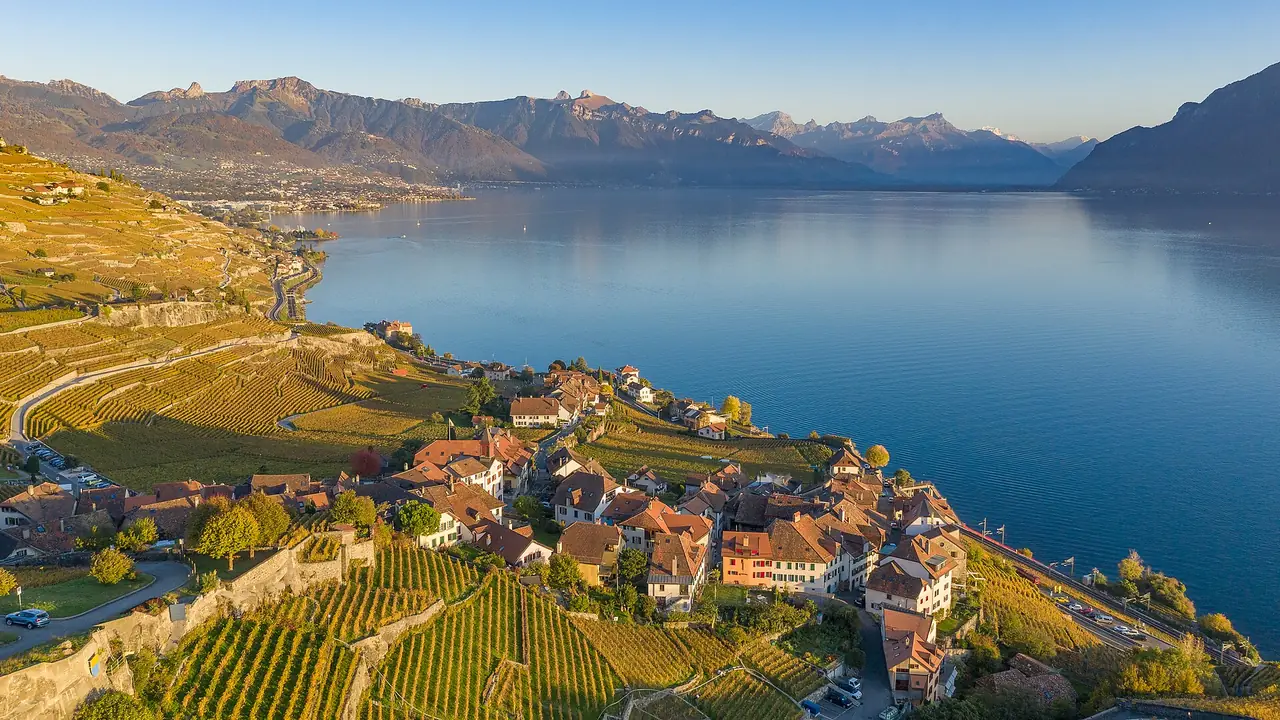 หมู่บ้านและไร่องุ่นขั้นบันไดของ Lavaux เหนือทะเลสาบเจนีวา ภาพจาก Wikimedia Commons ผู้ถ่าย Lorenz Poffet สัญญา CC BY-SA 4.0 ไม่ทราบวันที่ถ่าย ภาพมุมสูงช่วงแสงเย็น