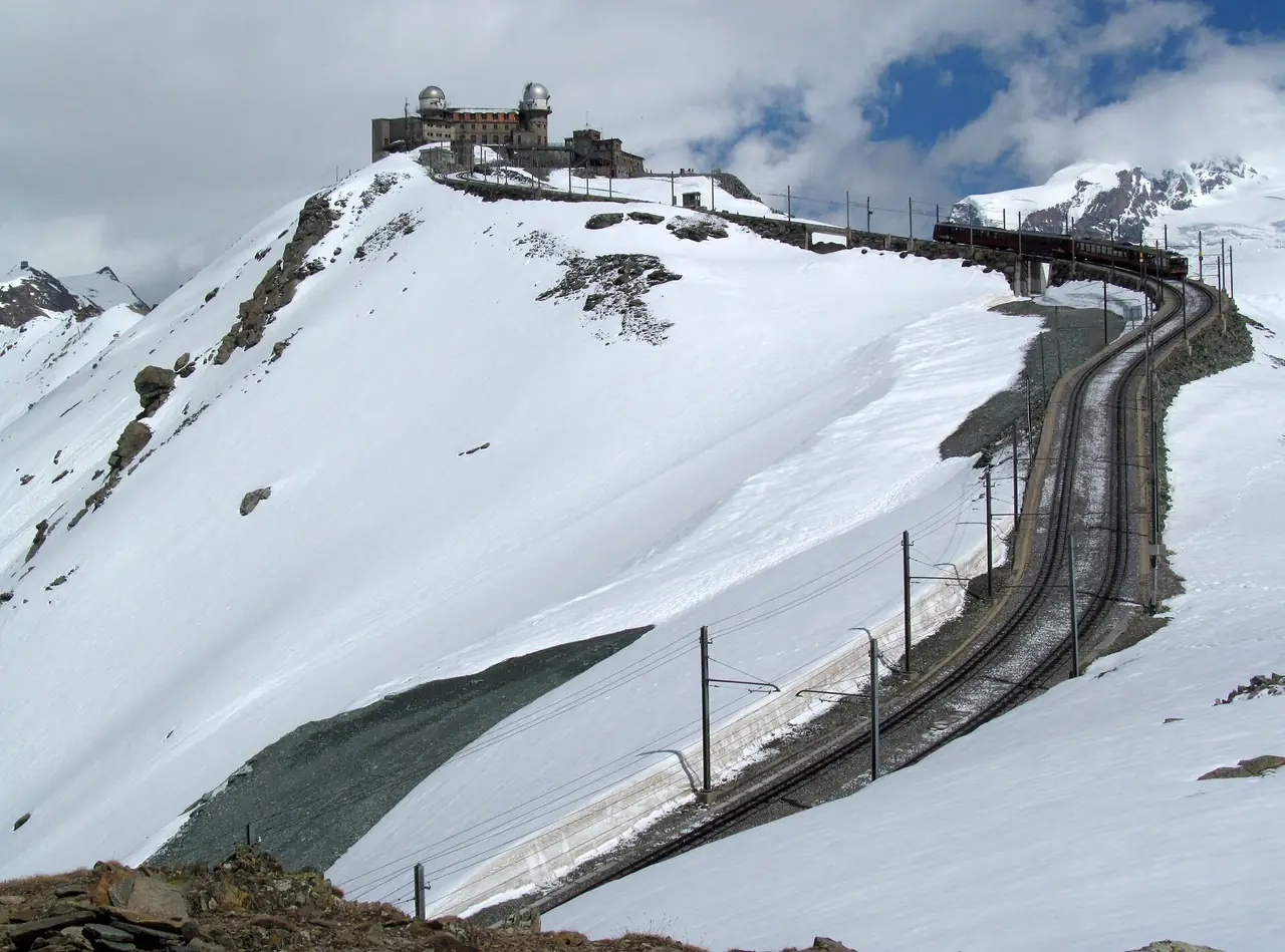 รถไฟรางฟันเฟือง Gornergrat เลี้ยวขึ้นเขาไปยังสถานีบนยอดซึ่งมีหอดูดาว ภาพจาก Wikimedia Commons เป็นภาพถ่ายของผู้ใช้ My another account at English Wikipedia สัญญา CC0 ไม่ระบุปีที่ถ่าย เป็นภาพประกอบ
