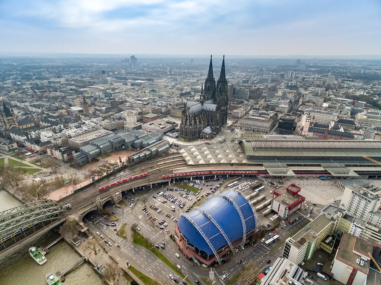 มุมสูงของมหาวิหารโคโลญและสถานีรถไฟกลาง ภาพจาก Wikimedia Commons ผู้ถ่าย dronepicr สัญญา CC BY 2.0 ปีที่ถ่ายไม่ระบุ
