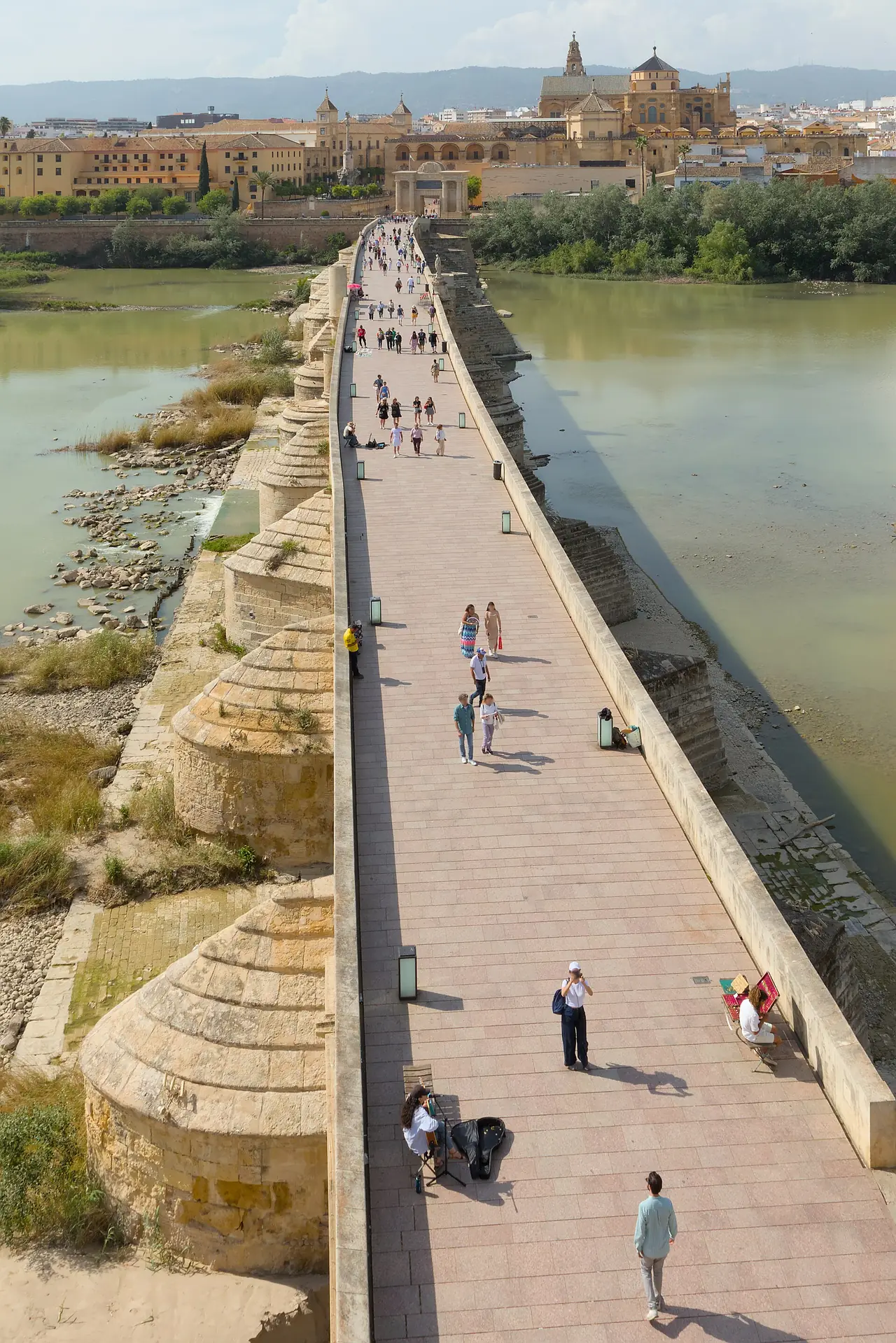 สะพานโรมันข้ามแม่น้ำกวาดัลกิบีร์ในกอร์โดบา เห็นมัสยิดมหาวิหารอยู่ไกล ๆ ภาพถ่ายจาก Wikimedia Commons ผู้ถ่าย Benjamin Smith สัญญา CC BY-SA 4.0