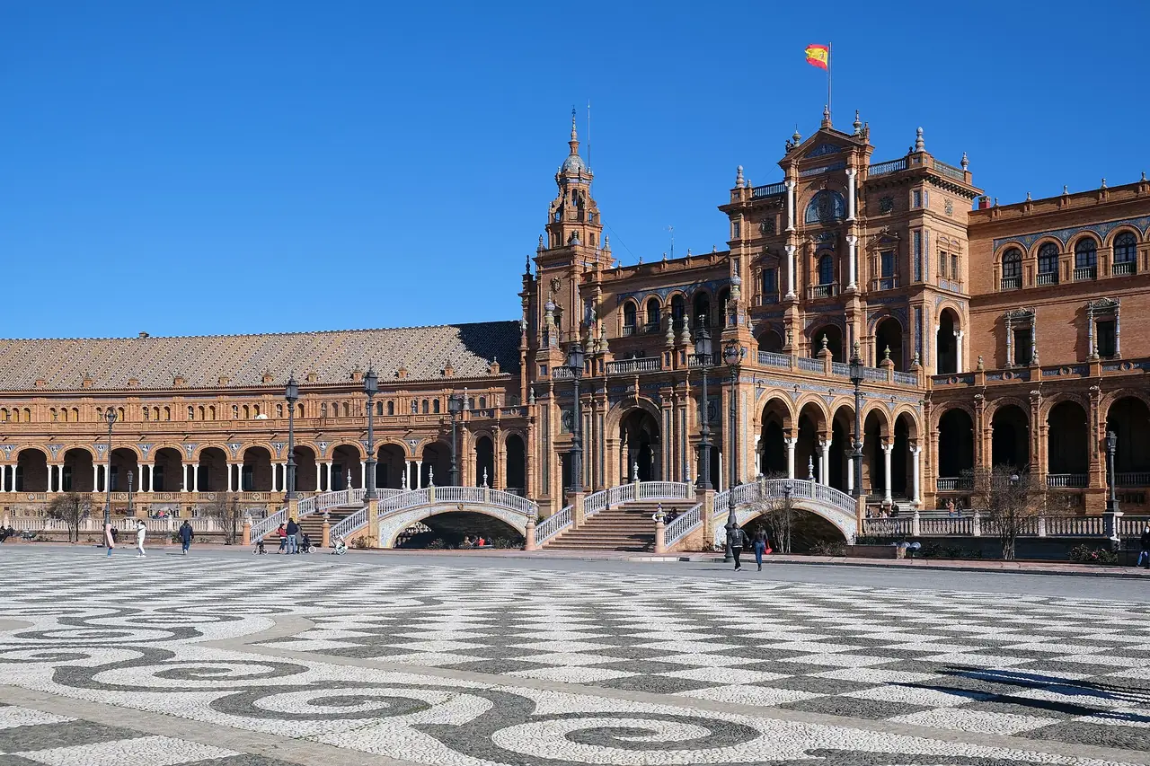 จัตุรัส Plaza de Espana ในเซบียา มีอาคารครึ่งวงกลมและสะพาน ภาพถ่ายจาก Wikimedia Commons ผู้ถ่าย kallerna สัญญา CC BY-SA 4.0