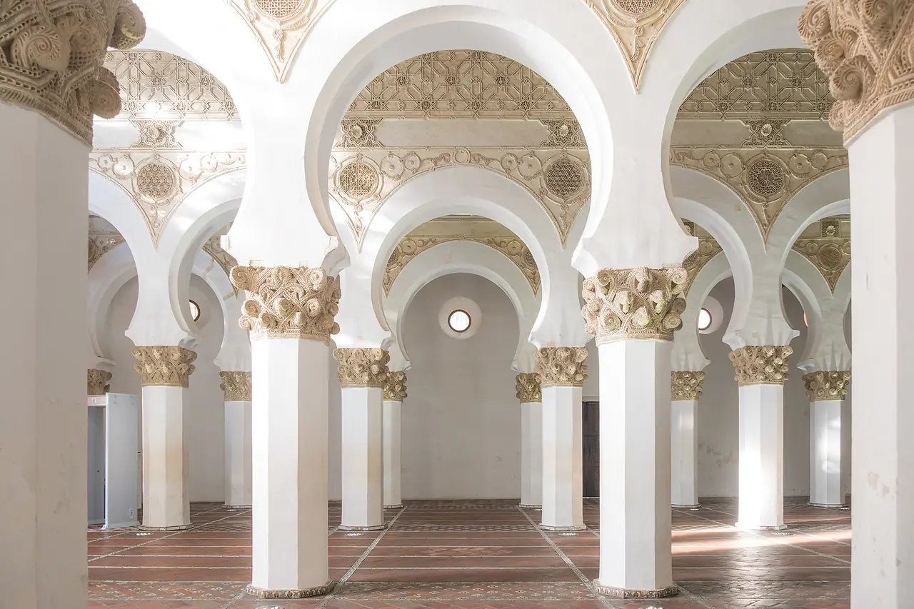 ภายในธรรมศาลา Santa Maria la Blanca ในโตเลโด เสาและโค้งสีขาว ภาพถ่ายจาก Wikimedia Commons ผู้ถ่าย Fernando สัญญา CC BY-SA 4.0