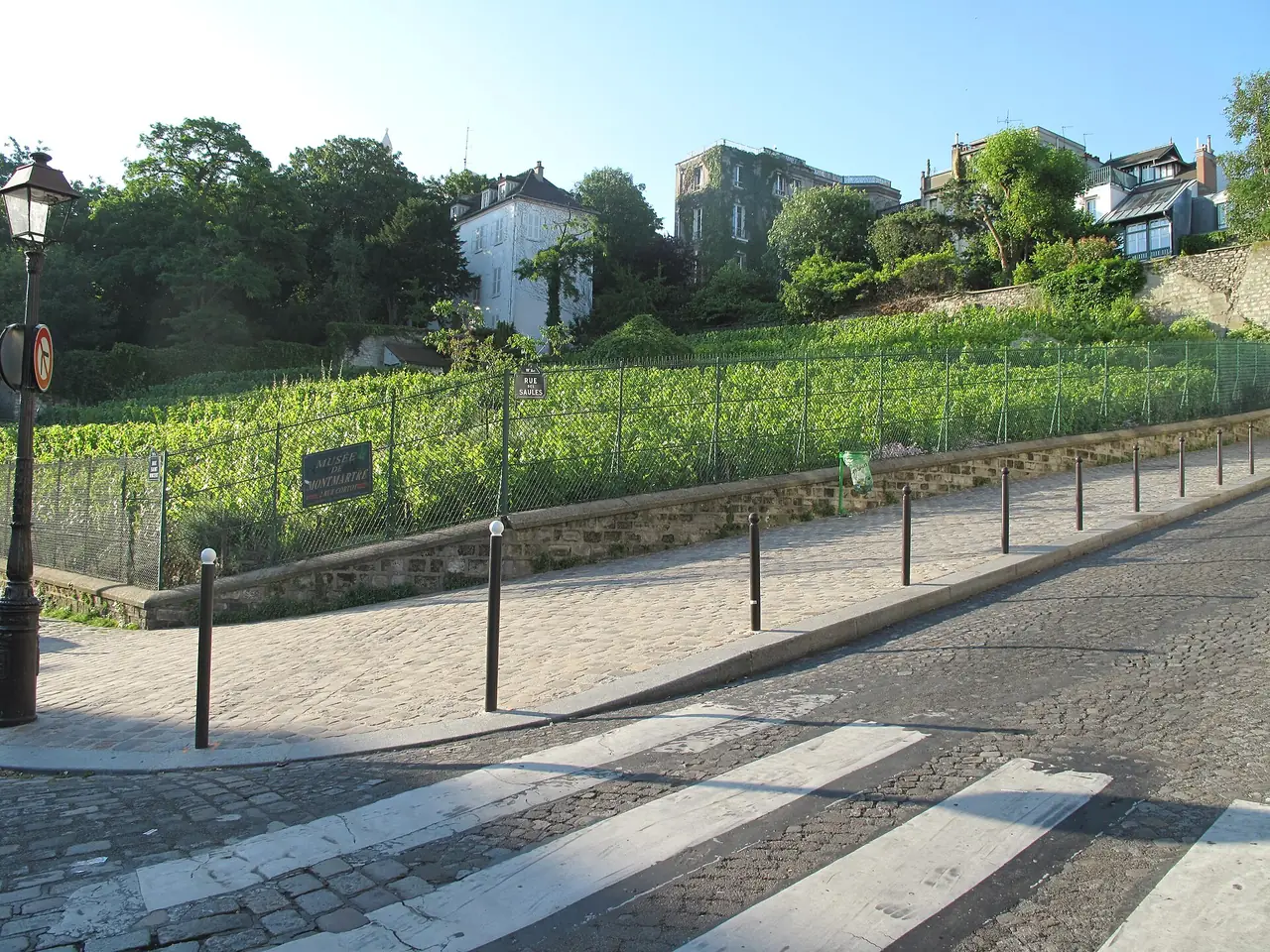 ไร่องุ่นเล็กของมงมาร์ตที่มุมถนน Rue des Saules กับ Rue Saint-Vincent ภาพจาก Wikimedia Commons ผู้ถ่าย Tangopaso เป็นสาธารณสมบัติ
