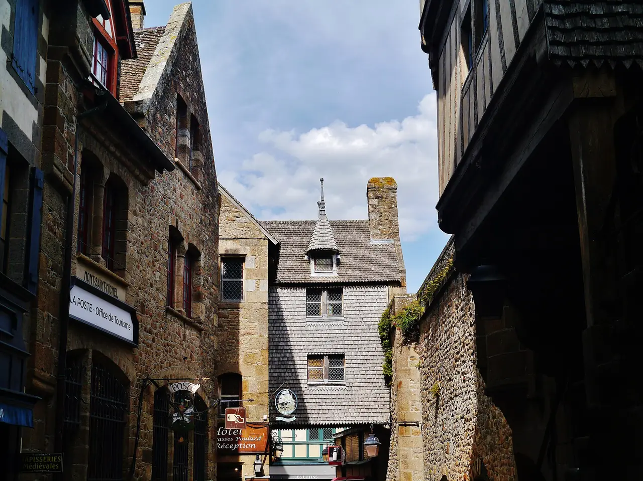 ถนน Grande Rue ในหมู่บ้านบนเกาะมงต์แซงต์มิเชล บ้านหินสองฝั่งทางเดินแคบ ภาพจาก Wikimedia Commons ผู้ถ่าย Zairon สัญญา CC BY-SA 4.0