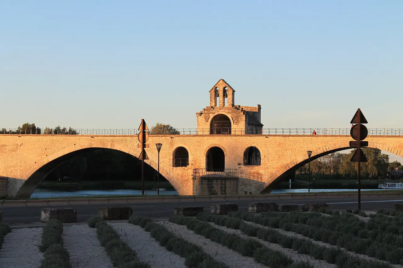 สะพาน Pont Saint-Bénézet (Pont d'Avignon) ตอนอาทิตย์ตก มองเห็นโบสถ์เล็กบนสะพาน ภาพจาก Wikimedia Commons ผู้ถ่าย John Samuel สัญญา CC BY-SA 4.0