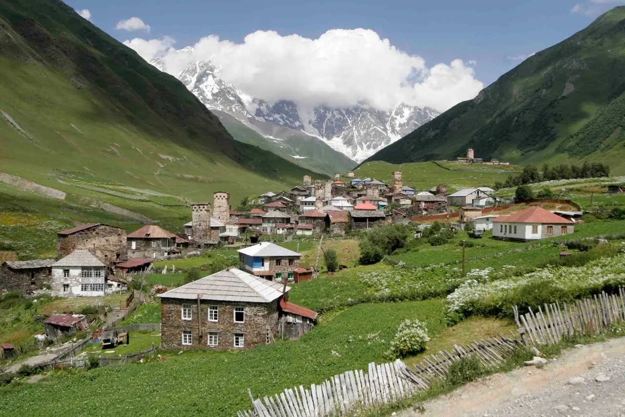 หมู่บ้านในหุบอุชกูลีกับยอดเขาหิมะด้านหลัง ภาพจาก Wikimedia Commons ผู้ถ่าย Giorgi Abdaladze สัญญา CC BY-SA 4.0 ชื่อไฟล์ระบุว่ามียอดชคาราเป็นฉากหลัง