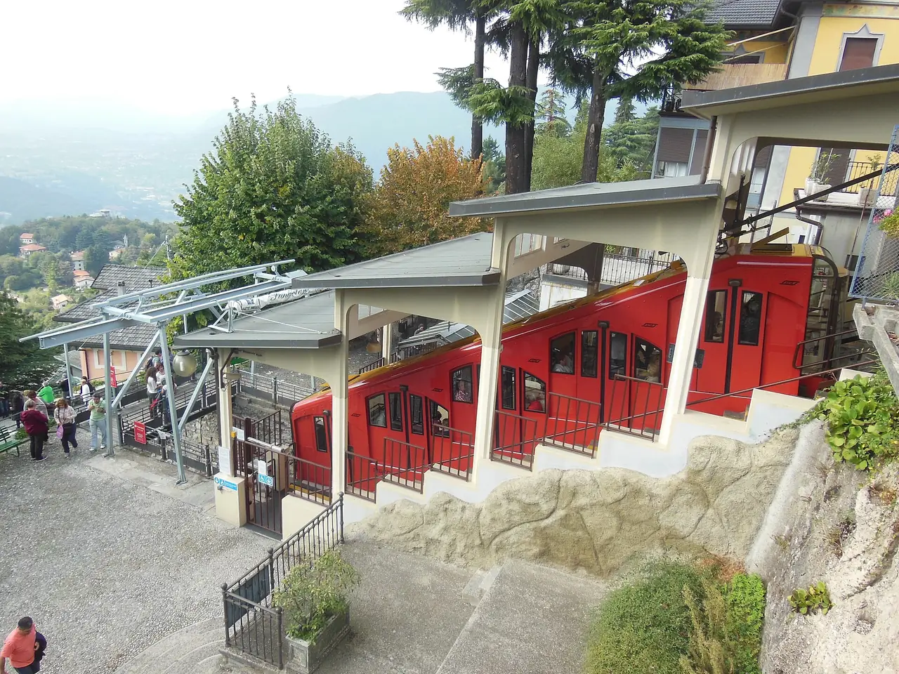 ขบวนรถรางกระเช้า Como-Brunate ที่สถานีด้านบน ภาพจาก Wikimedia Commons ผู้ถ่าย Chris j wood สัญญา CC BY-SA 3.0 ถ่ายเดือนตุลาคม 2555 เก่ามาก