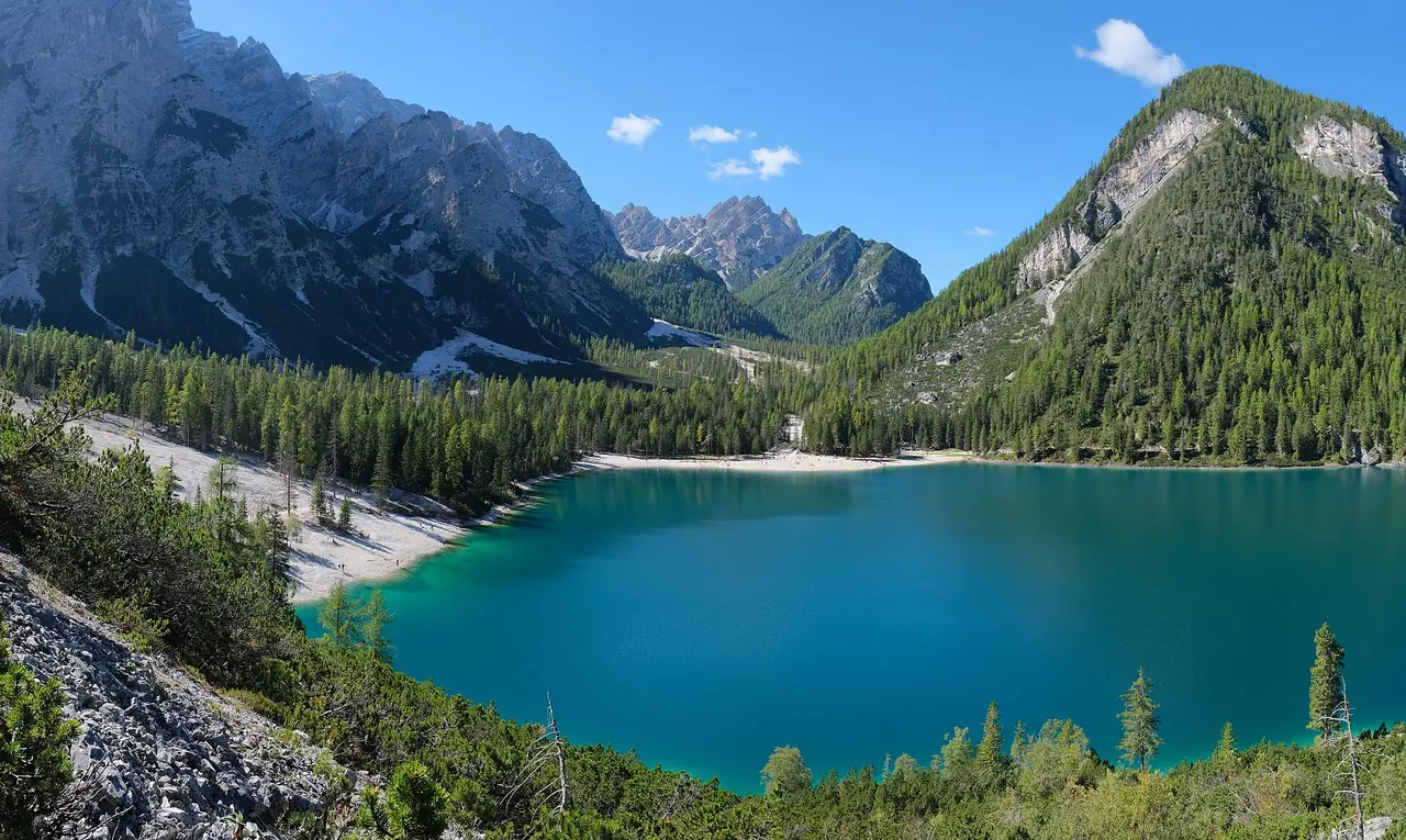 ภาพพาโนรามา Lago di Braies น้ำสีเขียวเทอร์ควอยซ์ล้อมด้วยป่าสนและหน้าผา ภาพจาก Wikimedia Commons ผู้ถ่าย kallerna สัญญา CC BY-SA 4.0