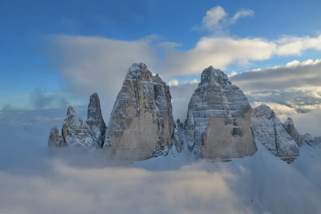 ยอด Tre Cime di Lavaredo เหนือทะเลเมฆ มีหิมะบางส่วน ภาพจาก Wikimedia Commons ผู้ถ่าย Wolfgang Moroder สัญญา CC BY-SA 3.0 ภาพหน้าหนาวหรือต้นฤดูหนาว