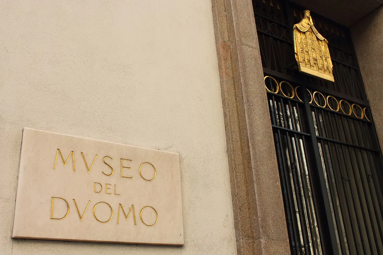 ป้ายและประตูทางเข้าพิพิธภัณฑ์ดูโอโม (Museo del Duomo) ภาพจาก Wikimedia Commons ผู้ถ่าย Stefano Stabile สัญญา CC BY-SA 3.0