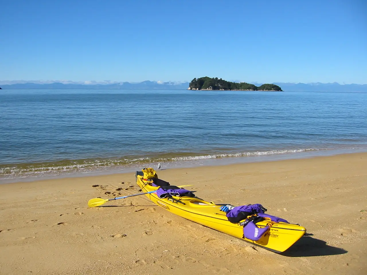 เรือคายัคสีเหลืองบนหาดทรายที่ Abel Tasman ตามคำบรรยายของ Commons ภาพจาก Wikimedia Commons ผู้ถ่าย Tobias Thierer สถานะ Public domain ไม่ระบุปี